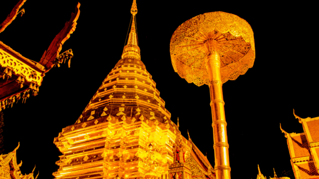 A golden pagoda in Yangon, Myanmar, shines out against a dark night sky.